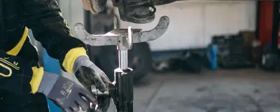 Mechanic repairing suspension on a lifted car