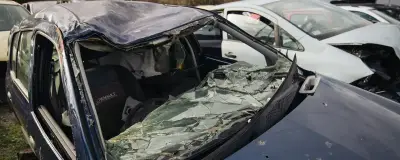 Car with a broken windscreen in a yard