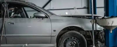 A partly dismantled car and tools in a workshop