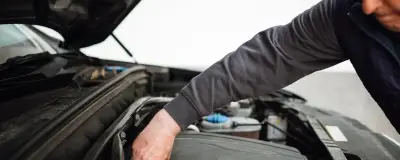 Mechanic inspecting a car engine during a pre-purchase check